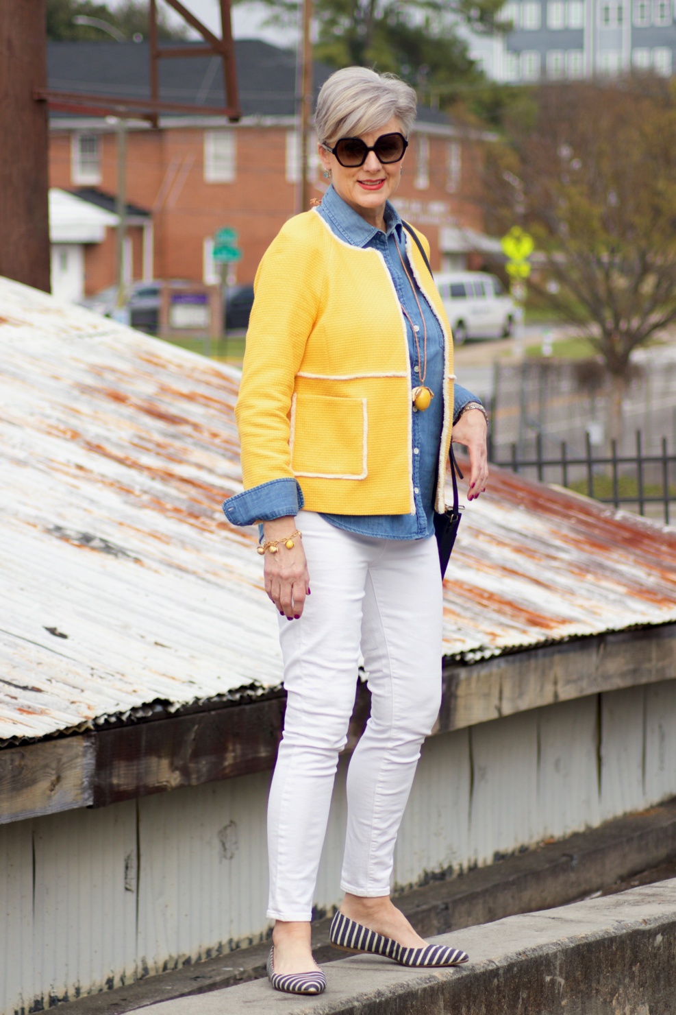 beth from Style at a Certain Age wears a Boden yellow blazer, chambray shirt, white denim and striped shoes