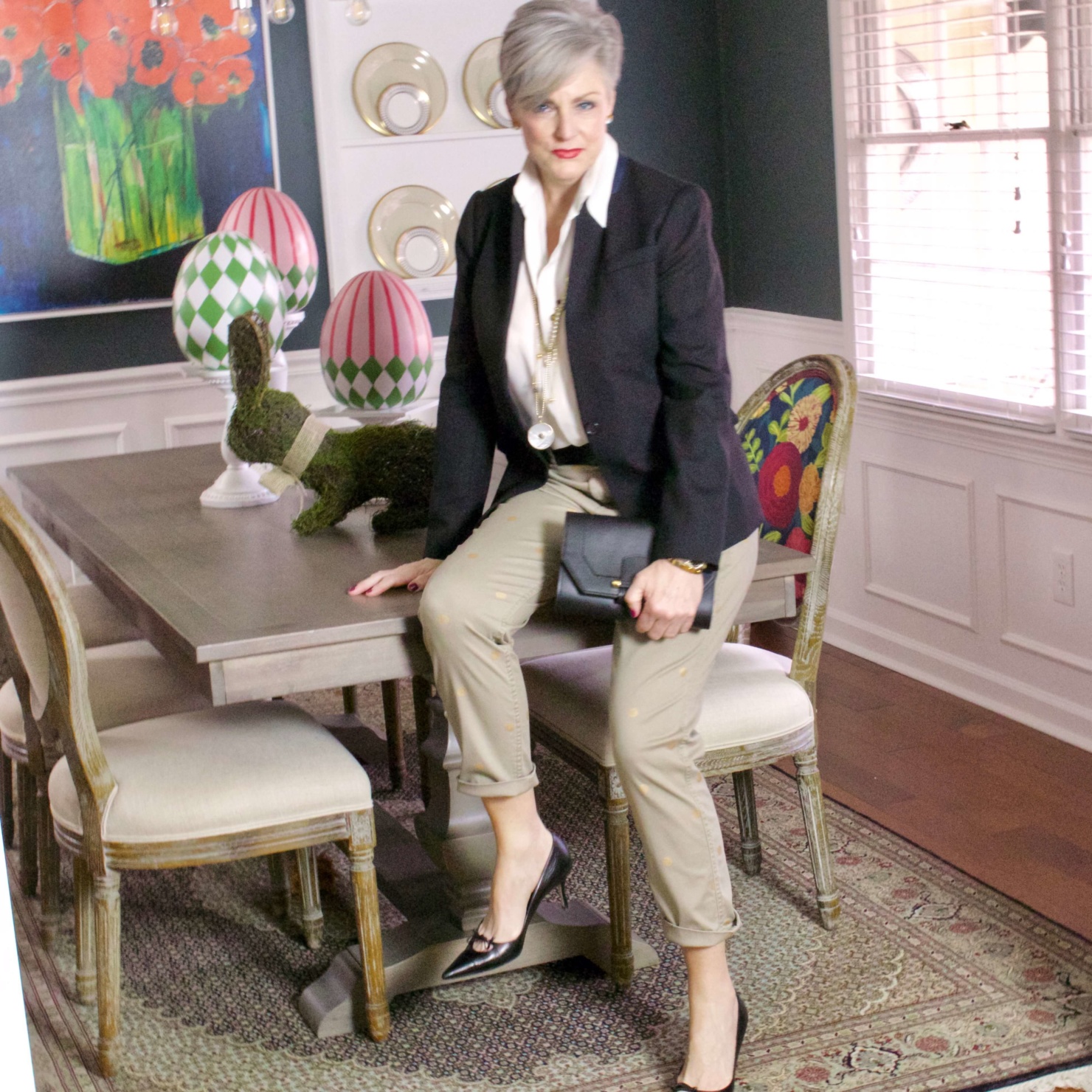 beth from Style at a Certain Age wears J.Crew chinos, black blazer, ivory silk blouse, black pumps and black clutch handbag