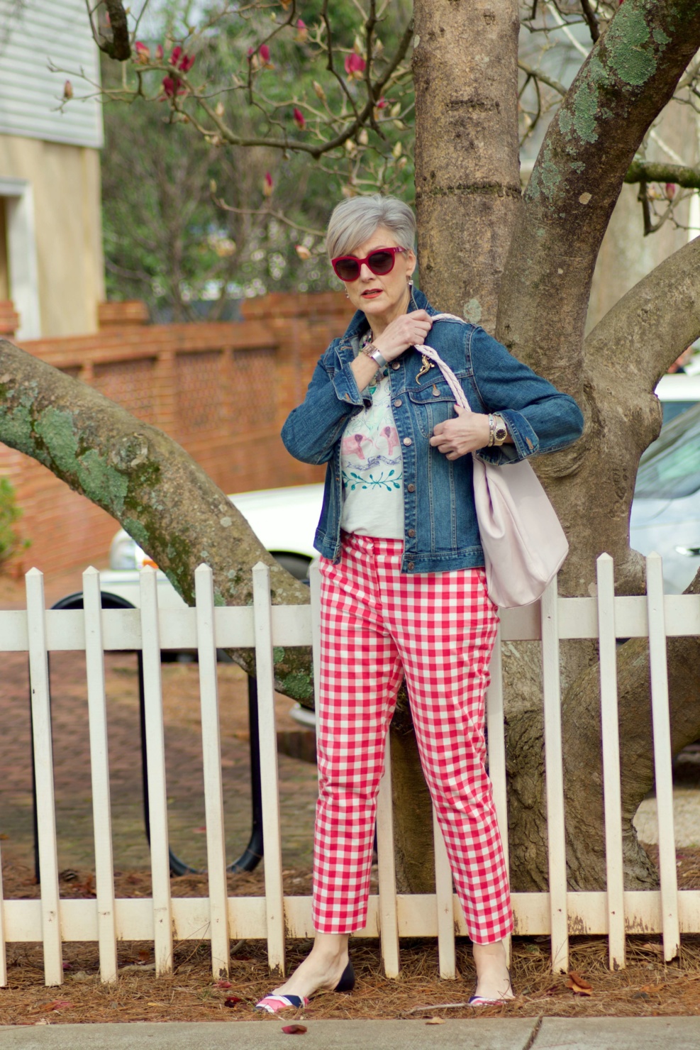 beth from Style at a Certain Age wears pink gingham pants, graphic tee, and denim jacket