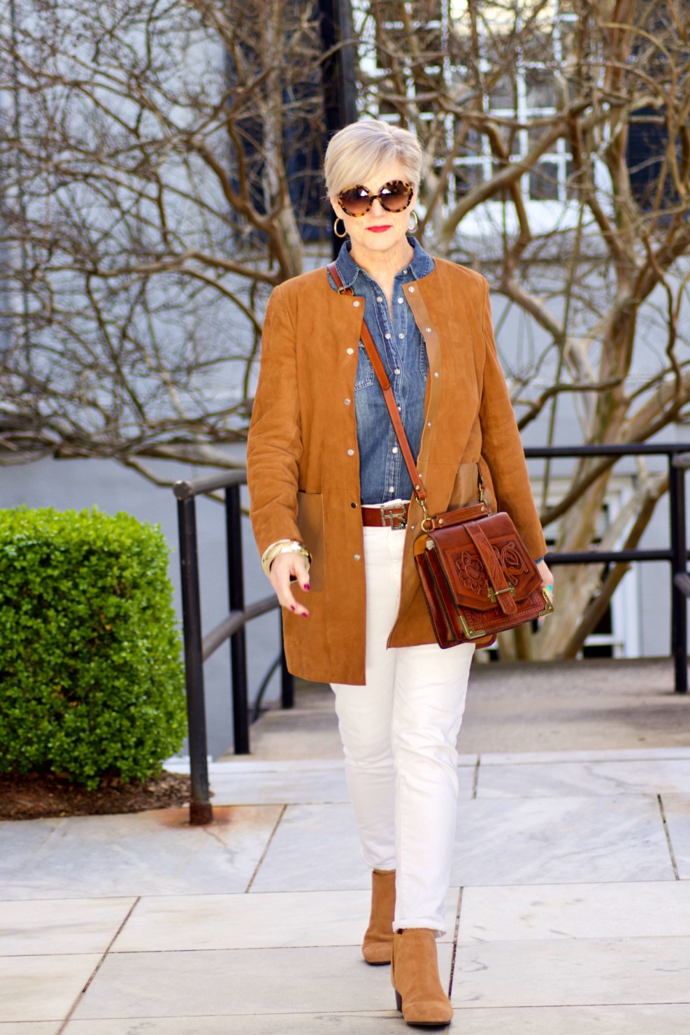 beth from Style at a Certain Age wears white denim, chambray shirt, suede jacket and booties