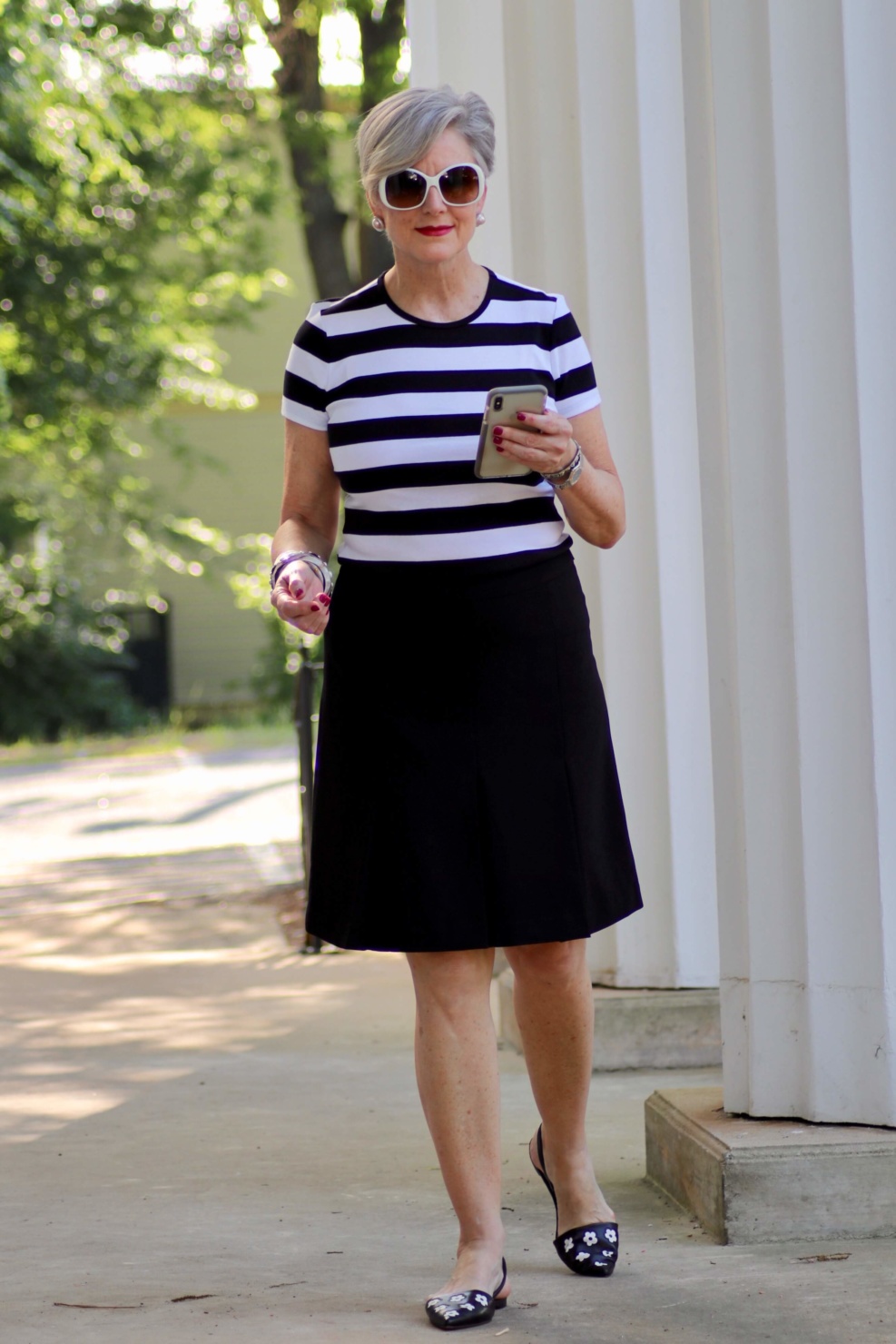 beth from Style at a Certain Age wears a black and white tee, black a-line skirt, pointy toed flats and black handbag