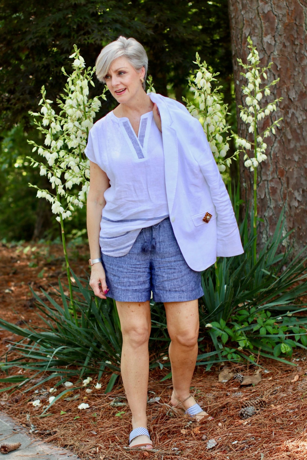 beth from Style at a Certain Age wears a classic summer blazer, drawstring shorts, seersucker sandals, and striped linen top