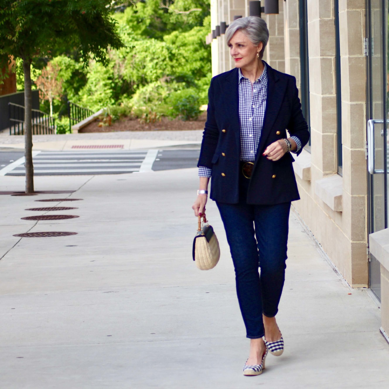 beth from Style at a Certain Age wears a lightweight blazer, gingham shirt, skinny jeans, espadrilles and wicker handbag