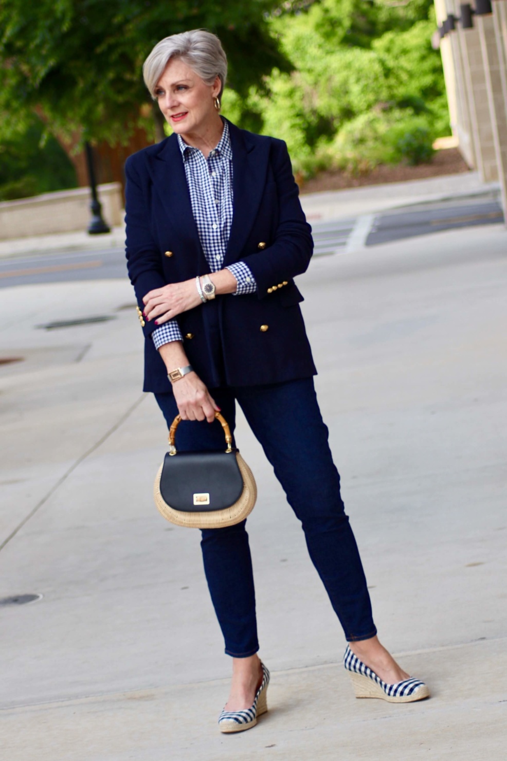 beth from Style at a Certain Age wears a lightweight blazer, gingham shirt, skinny jeans, espadrilles and wicker handbag