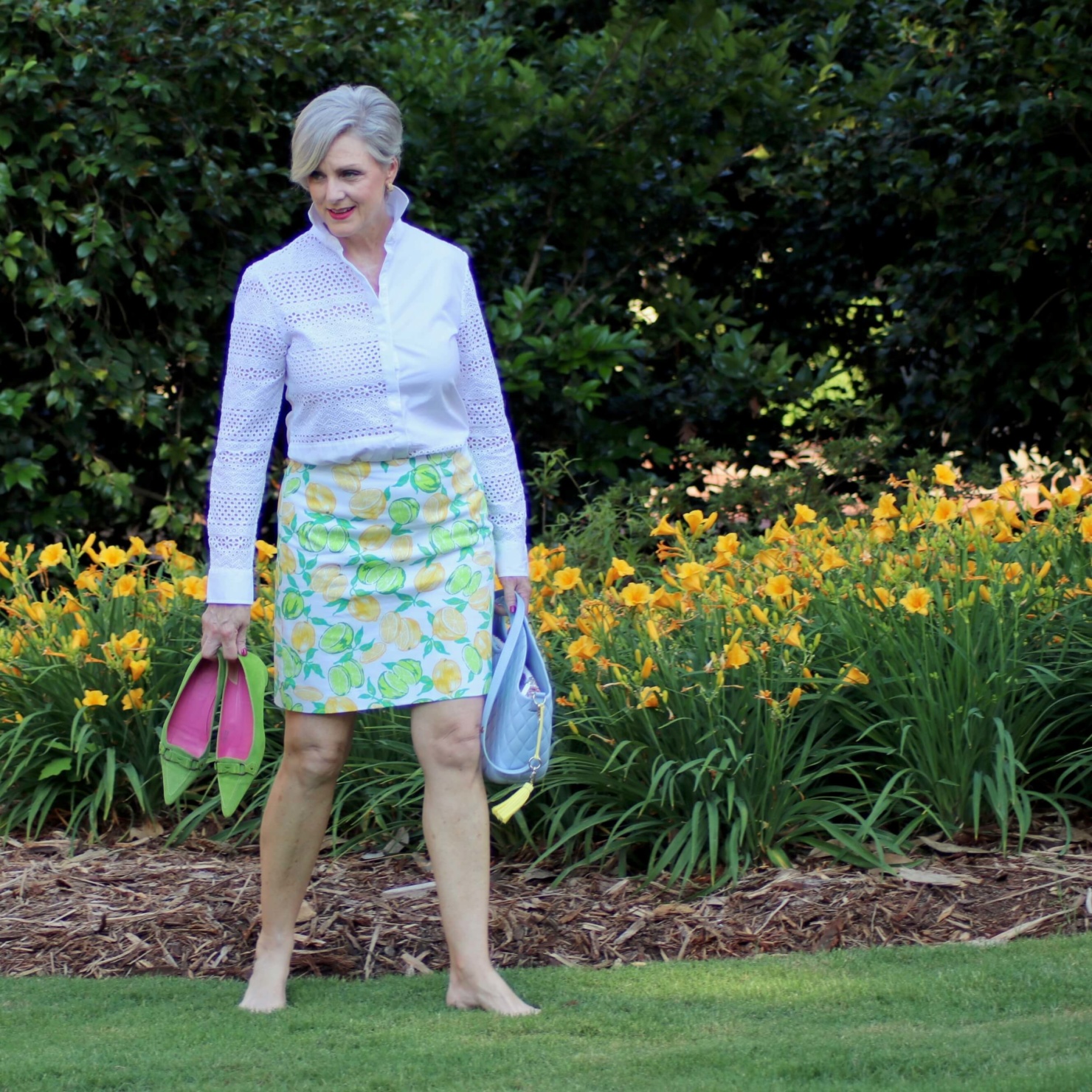 beth from Style at a Certain Age wears a lemon print skirt, eyelet blouse, pointy-toed flats and o-bag