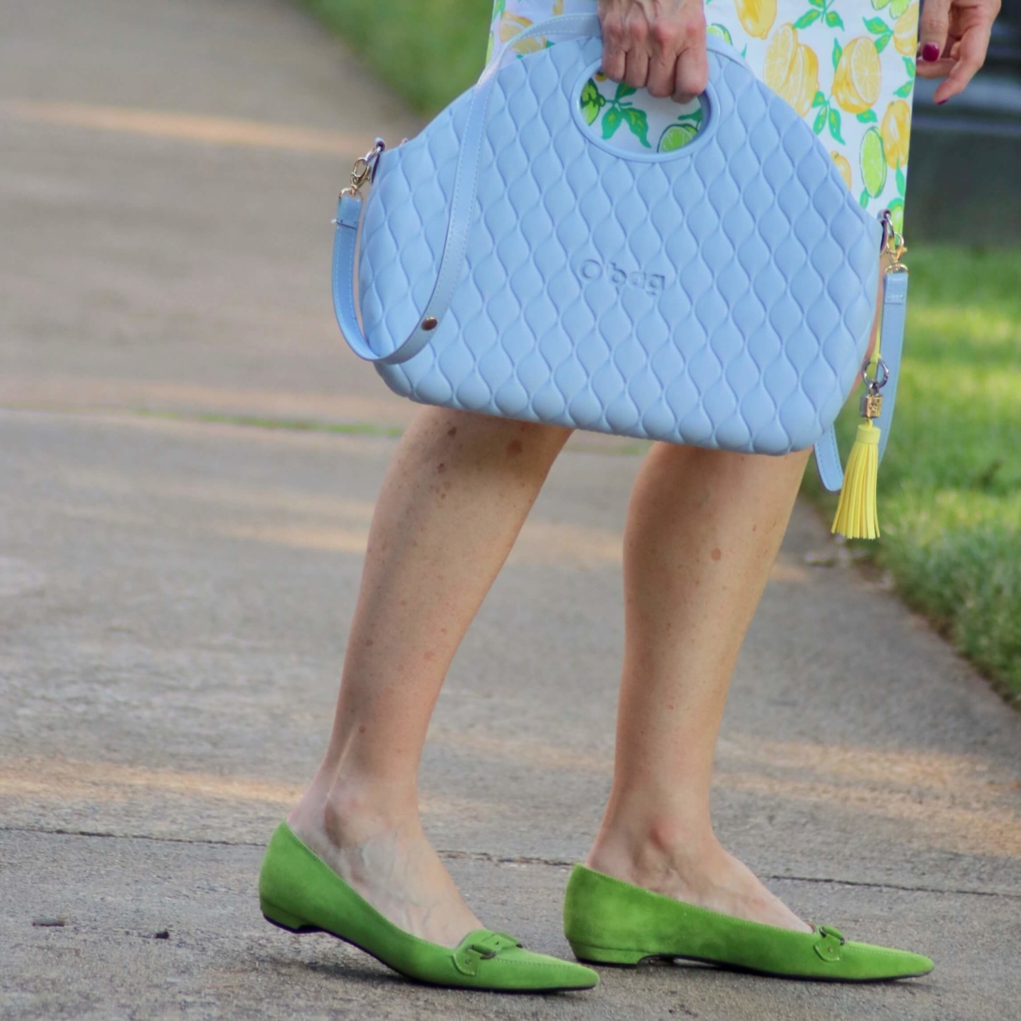 beth from Style at a Certain Age wears a lemon print skirt, eyelet blouse, pointy-toed flats and o-bag
