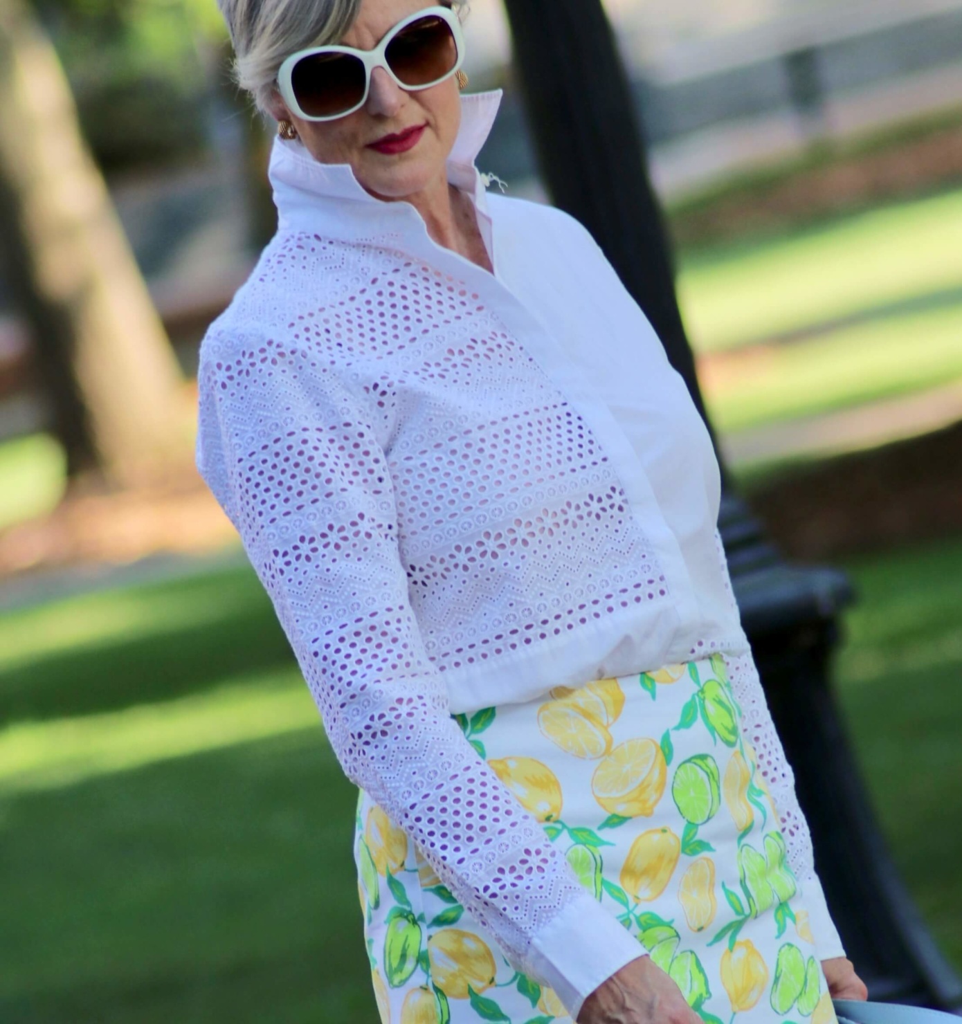beth from Style at a Certain Age wears a lemon print skirt, eyelet blouse, pointy-toed flats and o-bag