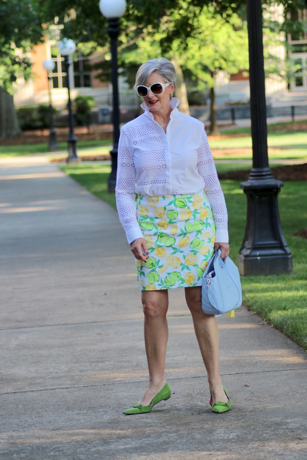 beth from Style at a Certain Age wears a lemon print skirt, eyelet blouse, pointy-toed flats and o-bag