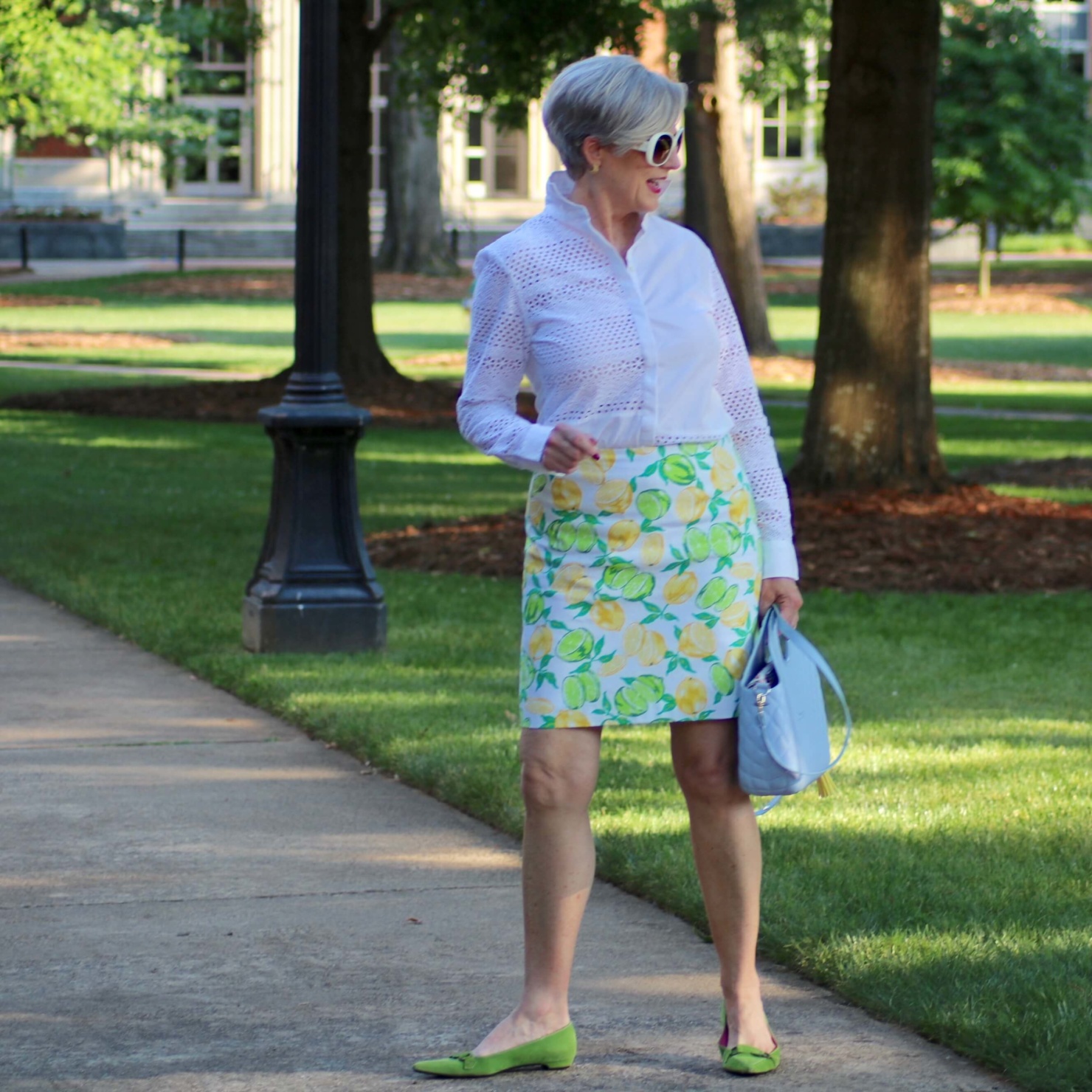 beth from Style at a Certain Age wears a lemon print skirt, eyelet blouse, pointy-toed flats and o-bag