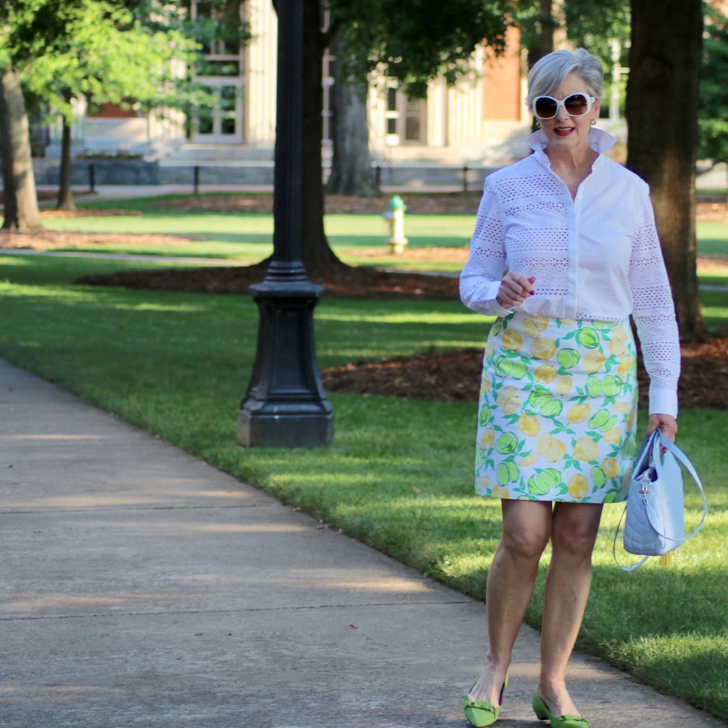 beth from Style at a Certain Age wears a lemon print skirt, eyelet blouse, pointy-toed flats and o-bag