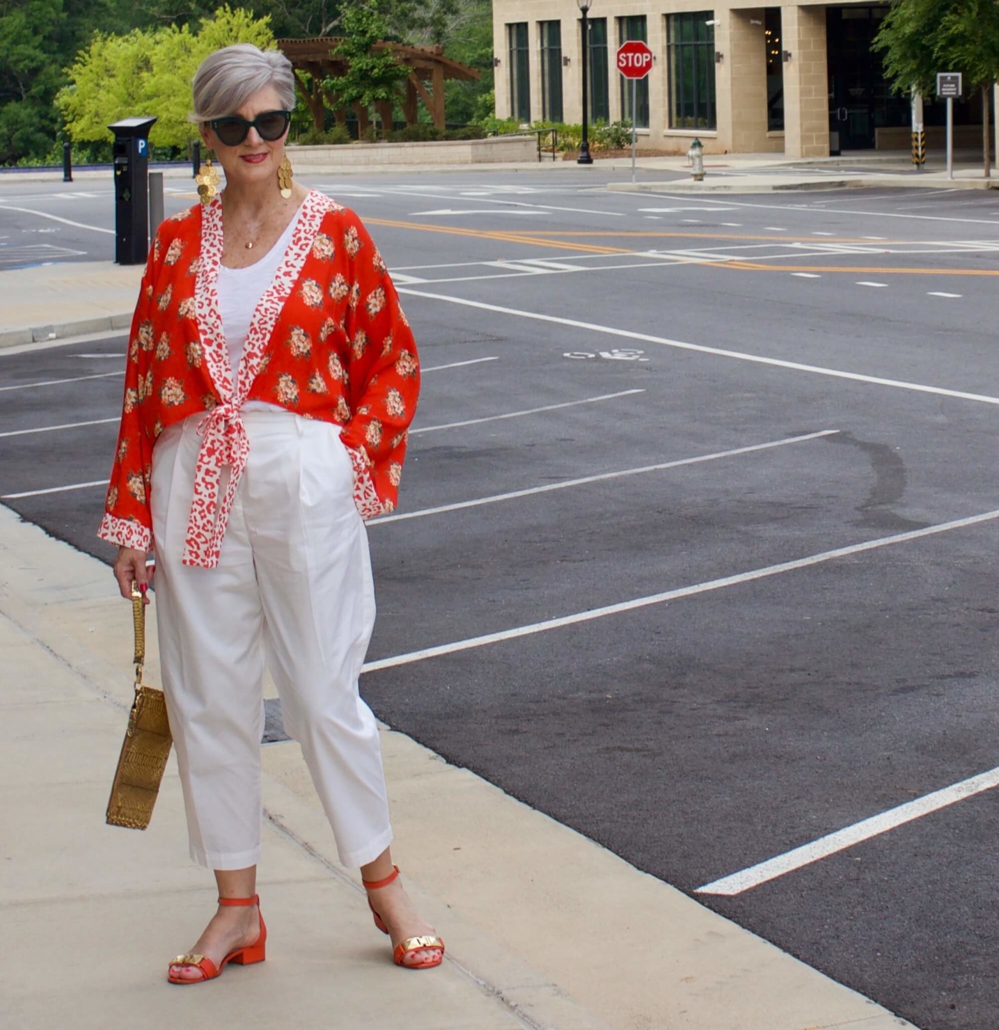 beth from Style at a Certain Age wears a kimono, white cropped chinos, white tee and orange sandals
