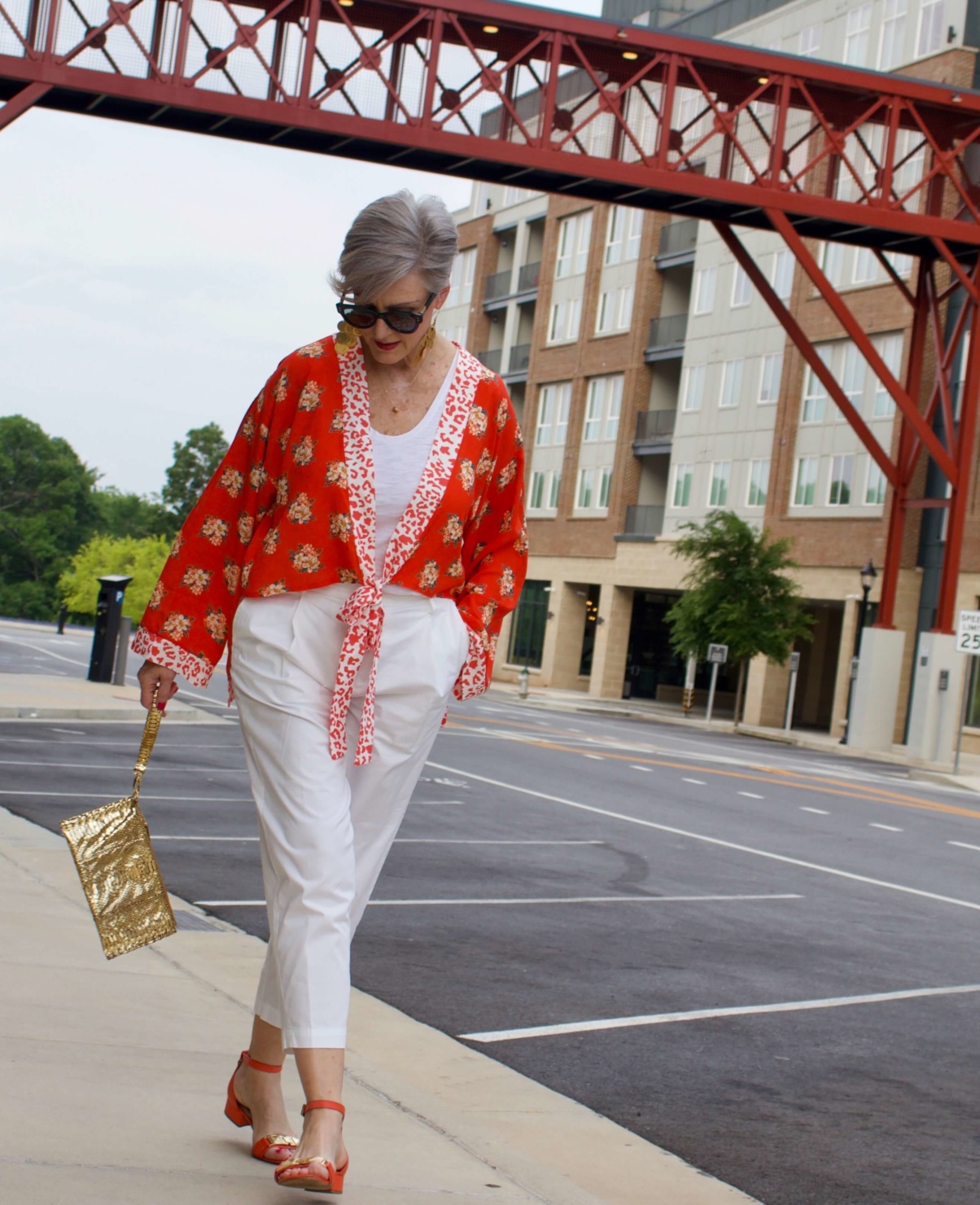 beth from Style at a Certain Age wears a kimono, white cropped chinos, white tee and orange sandals