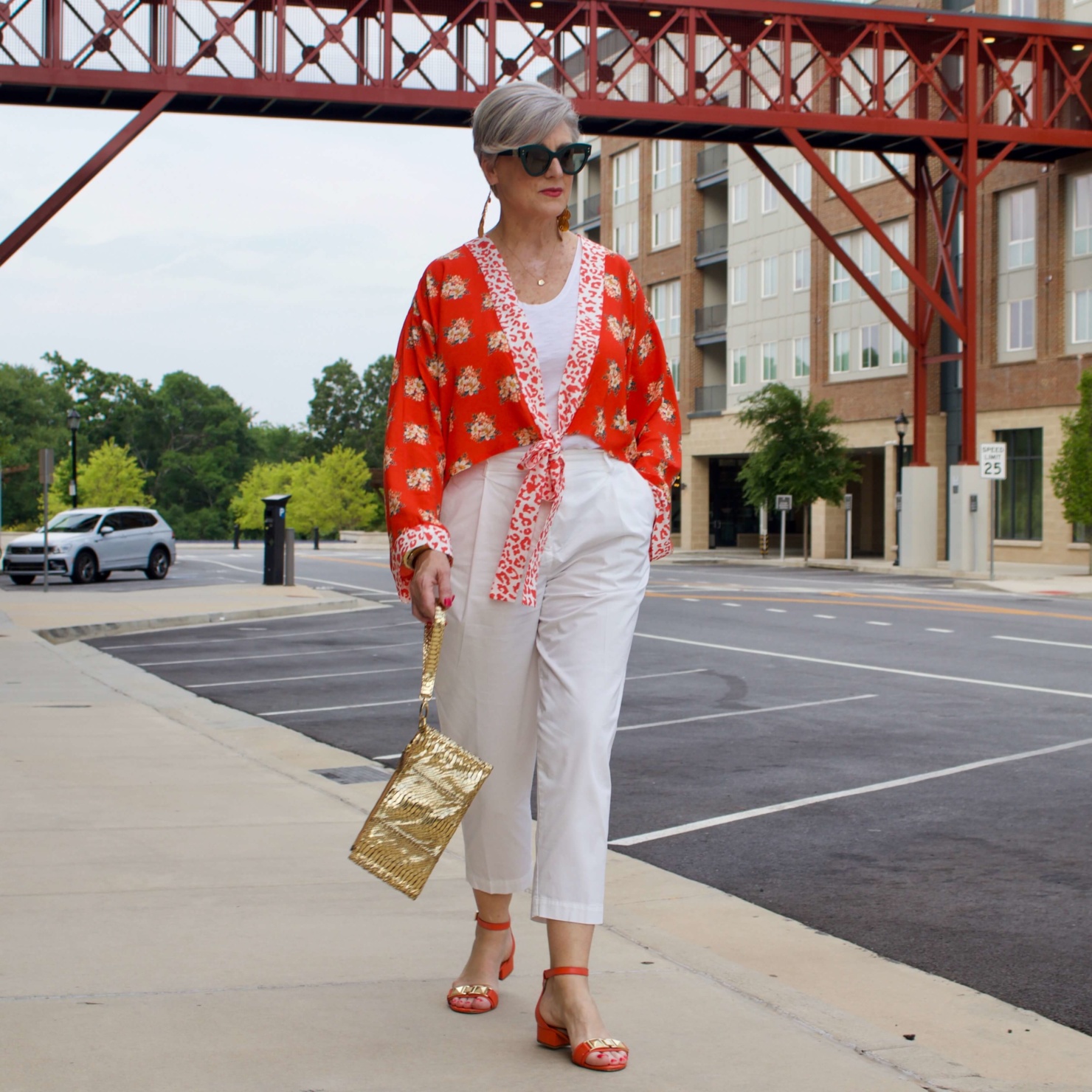 beth from Style at a Certain Age wears a kimono, white cropped chinos, white tee and orange sandals