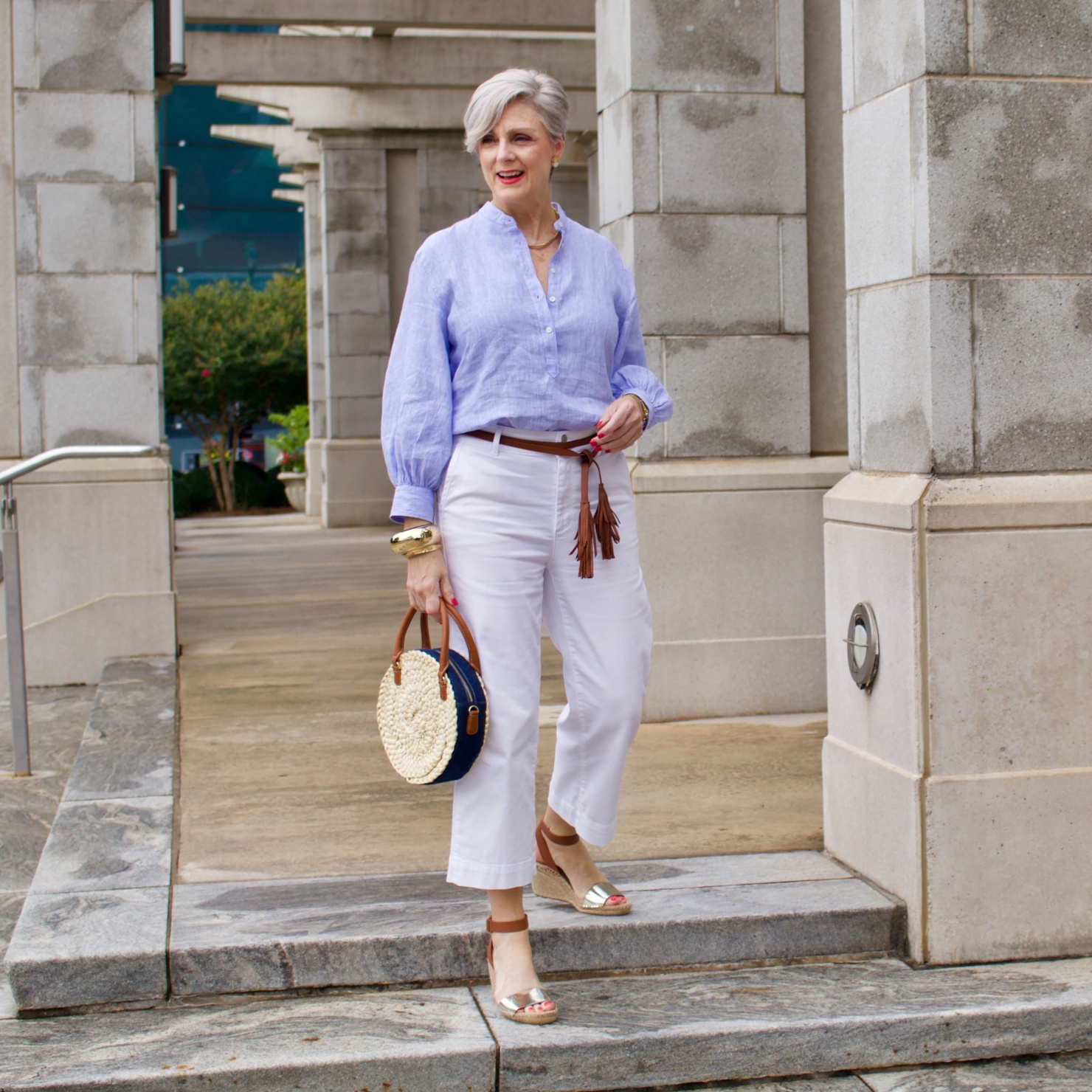 cropped white denim, striped linen shirt, cornhusk handbag, and wedge sandals