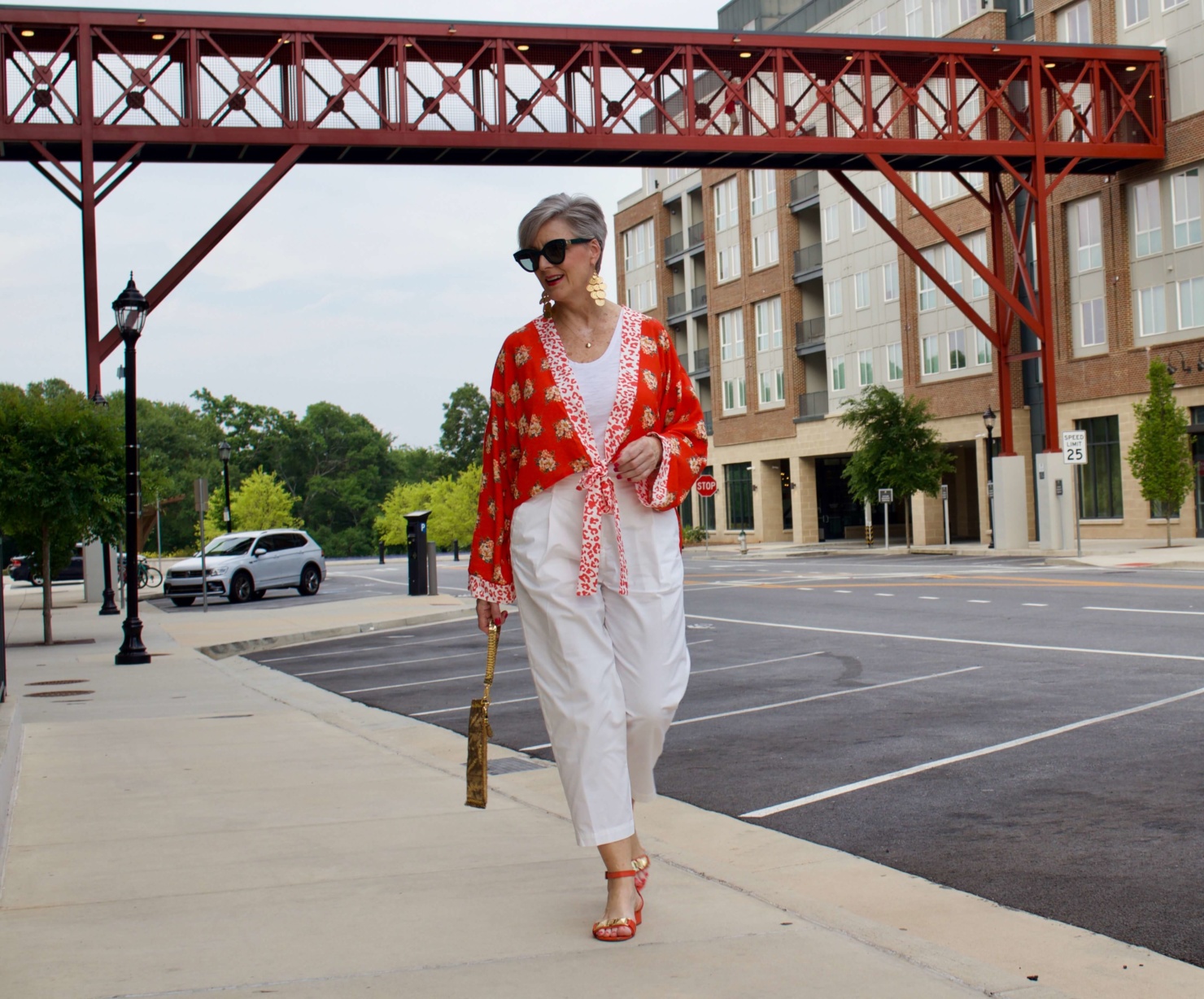 beth from Style at a Certain Age wears a kimono, white cropped chinos, white tee and orange sandals