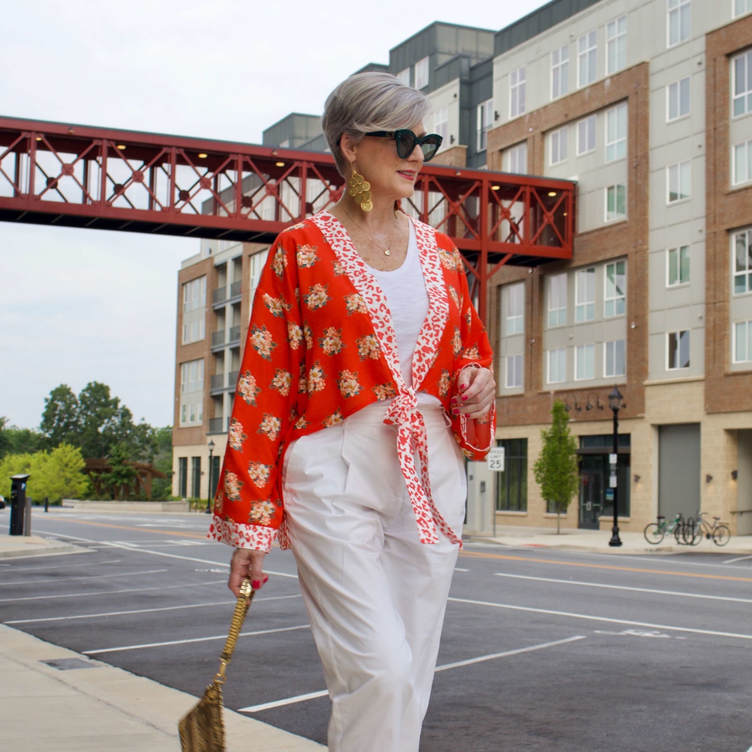 beth from Style at a Certain Age wears a kimono, white cropped chinos, white tee and orange sandals