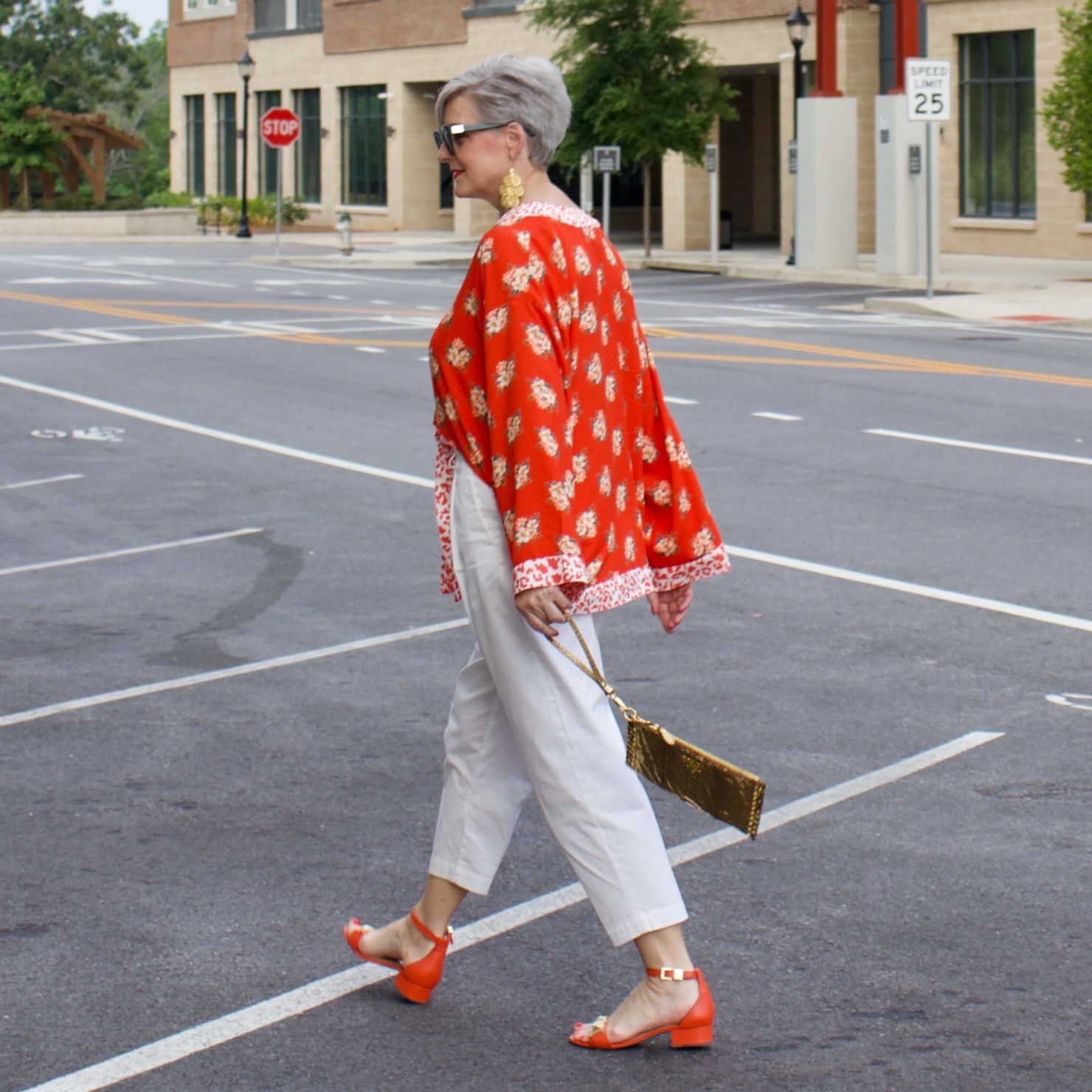 beth from Style at a Certain Age wears a kimono, white cropped chinos, white tee and orange sandals
