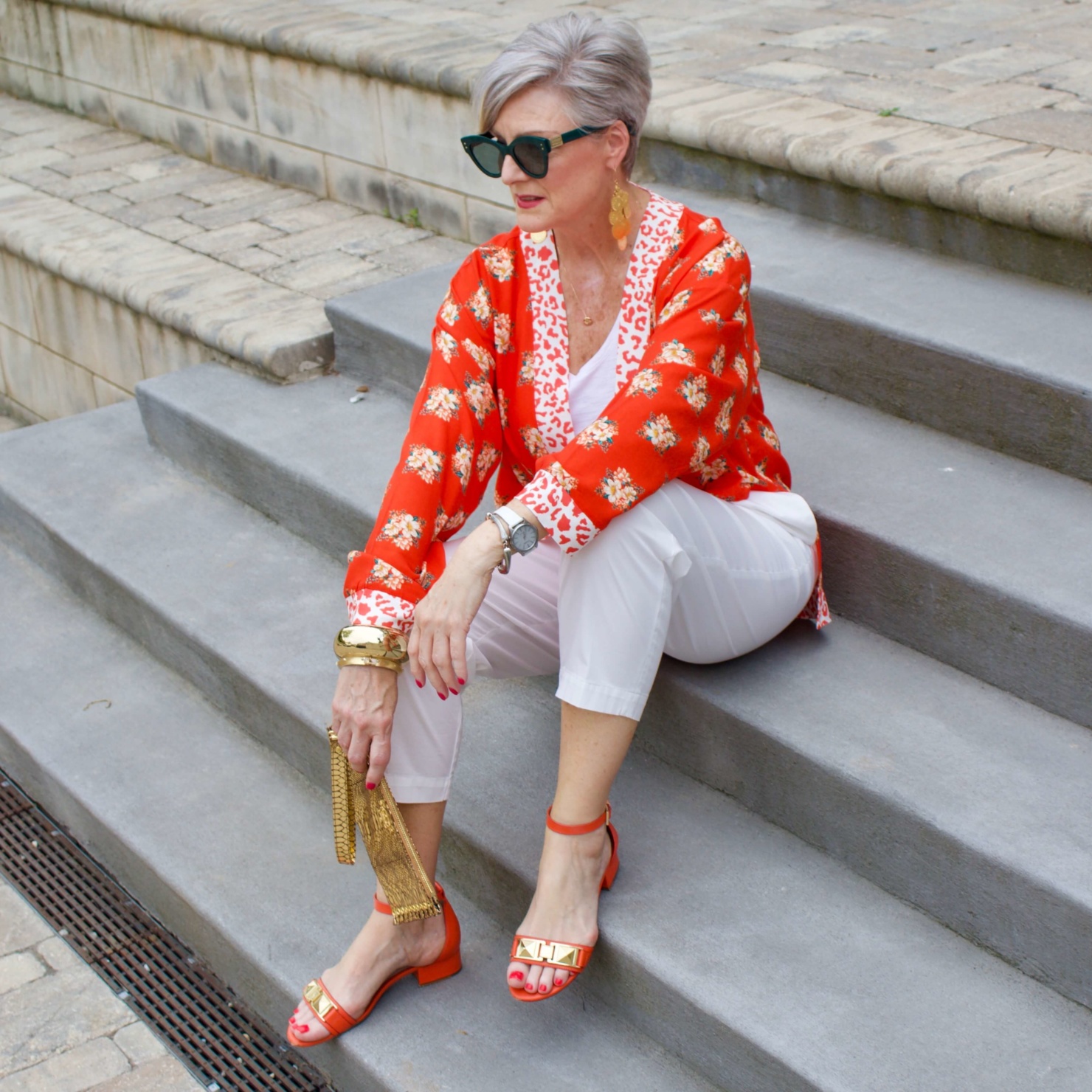 beth from Style at a Certain Age wears a kimono, white cropped chinos, white tee and orange sandals