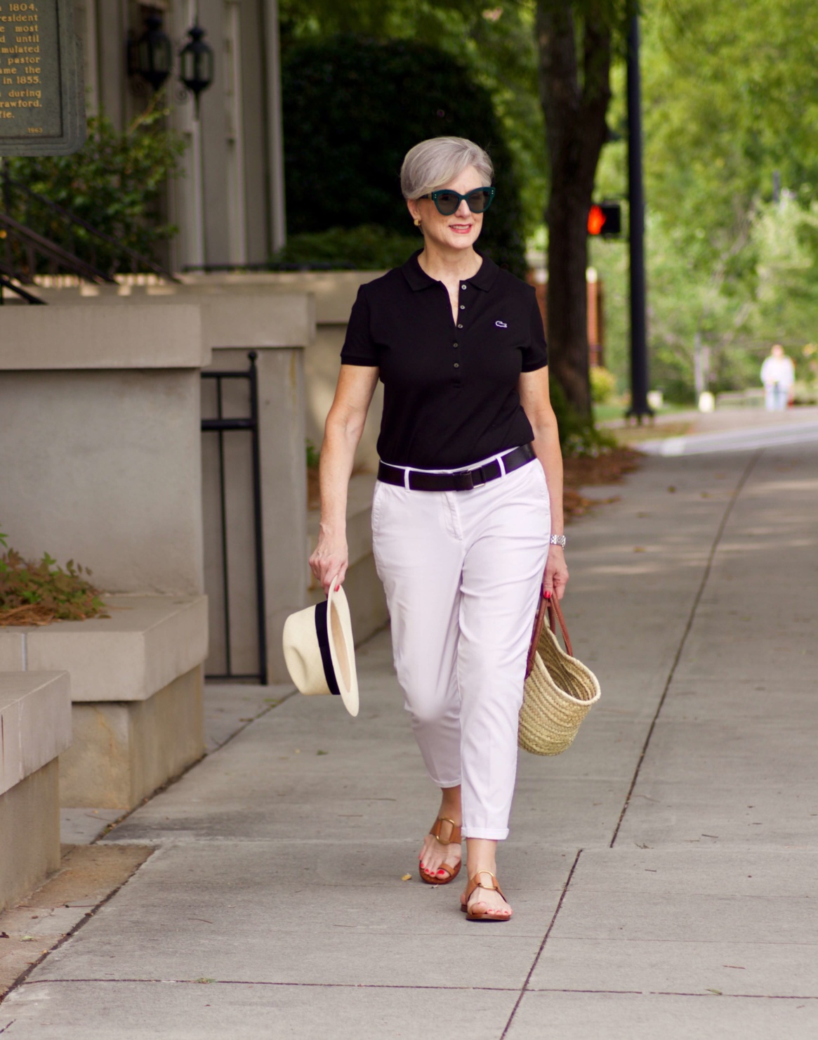 lacoste black polo, white chinos, brown sandals, straw tote