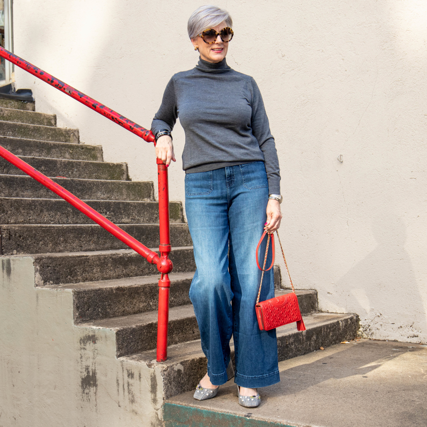 wide leg jeans, gray turtleneck, red handbag