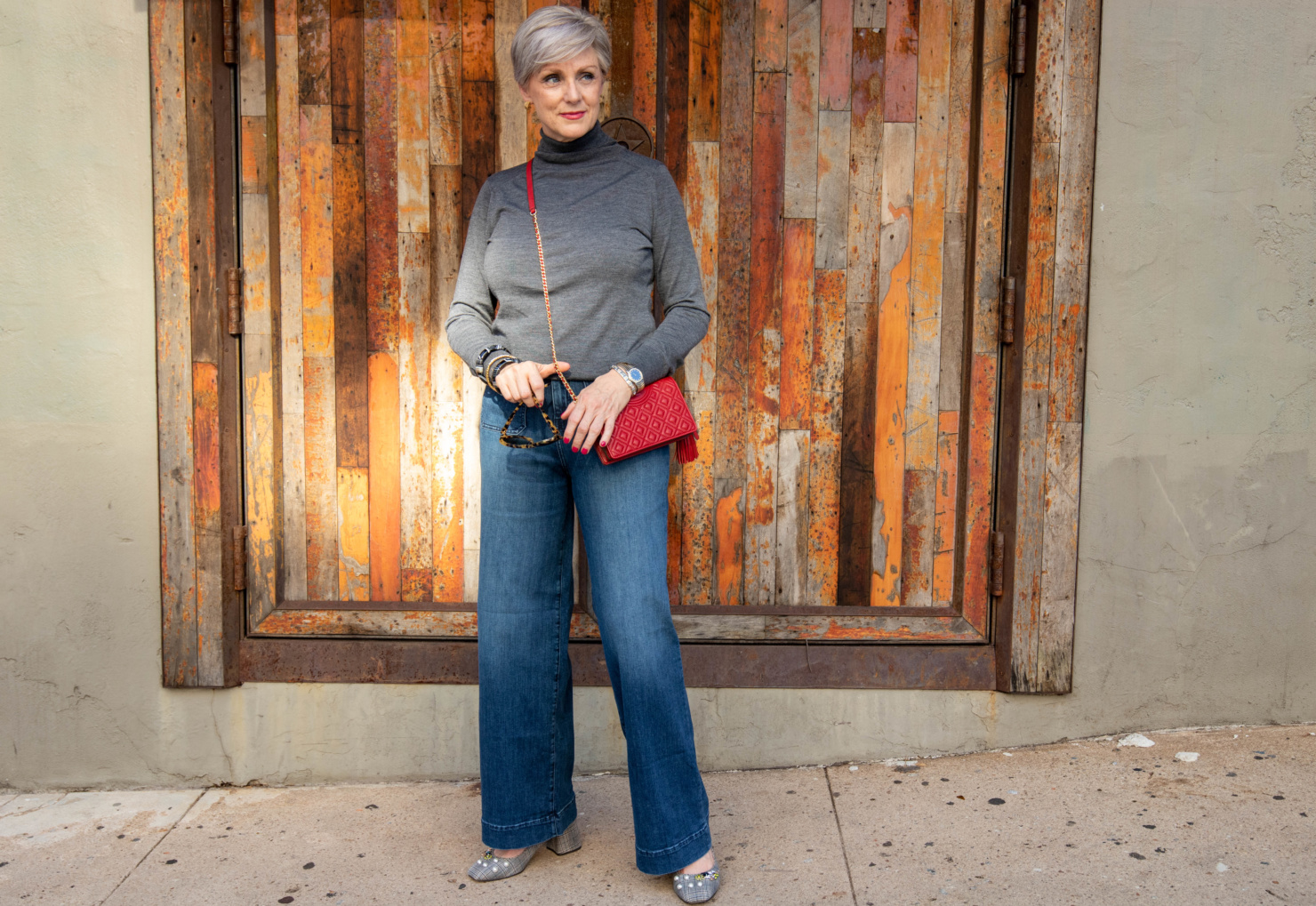wide leg jeans, gray turtleneck, red handbag