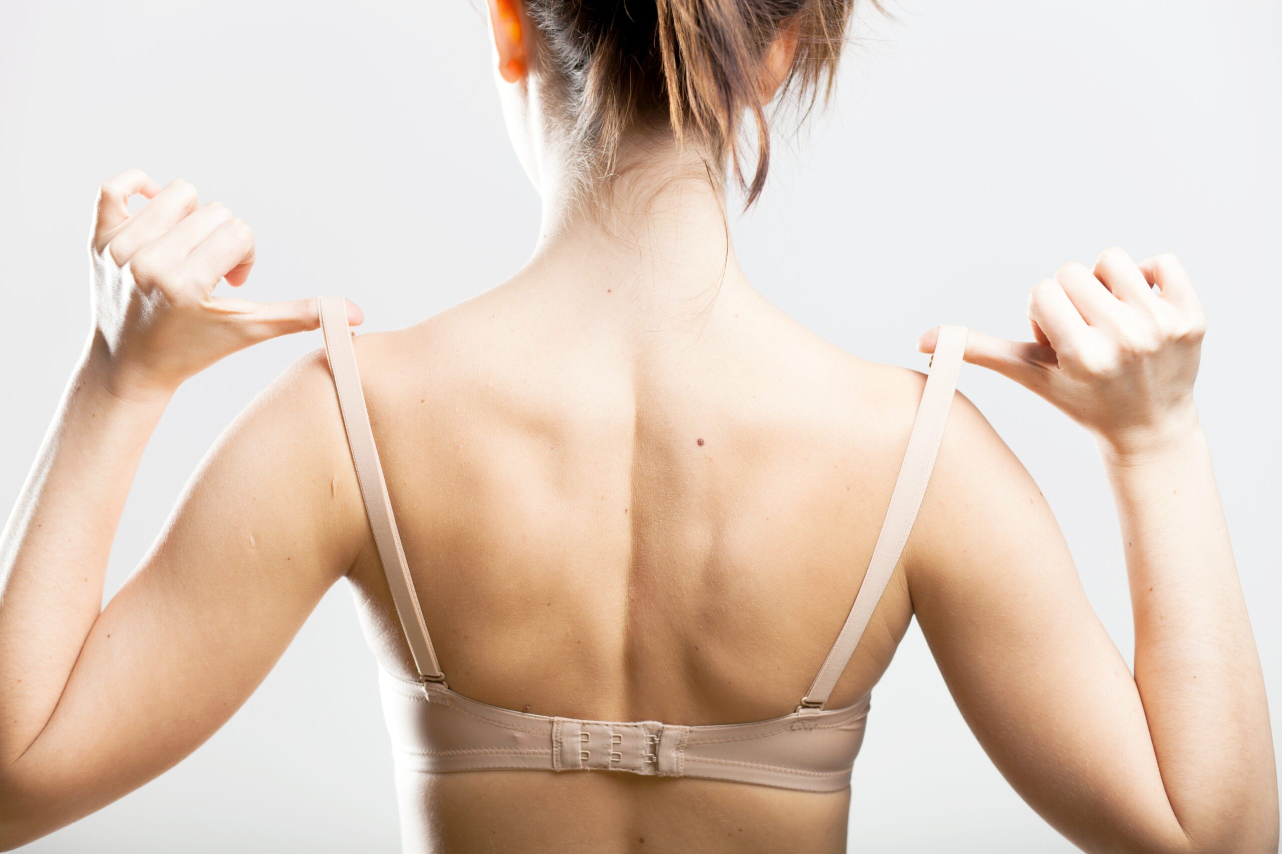 Woman,Holding,A,Skin,Colored,Bra,Strap,,Closeup,Back,View Woman,Holding,A,Skin,Colored,Bra,Strap,,Closeup,Back,View