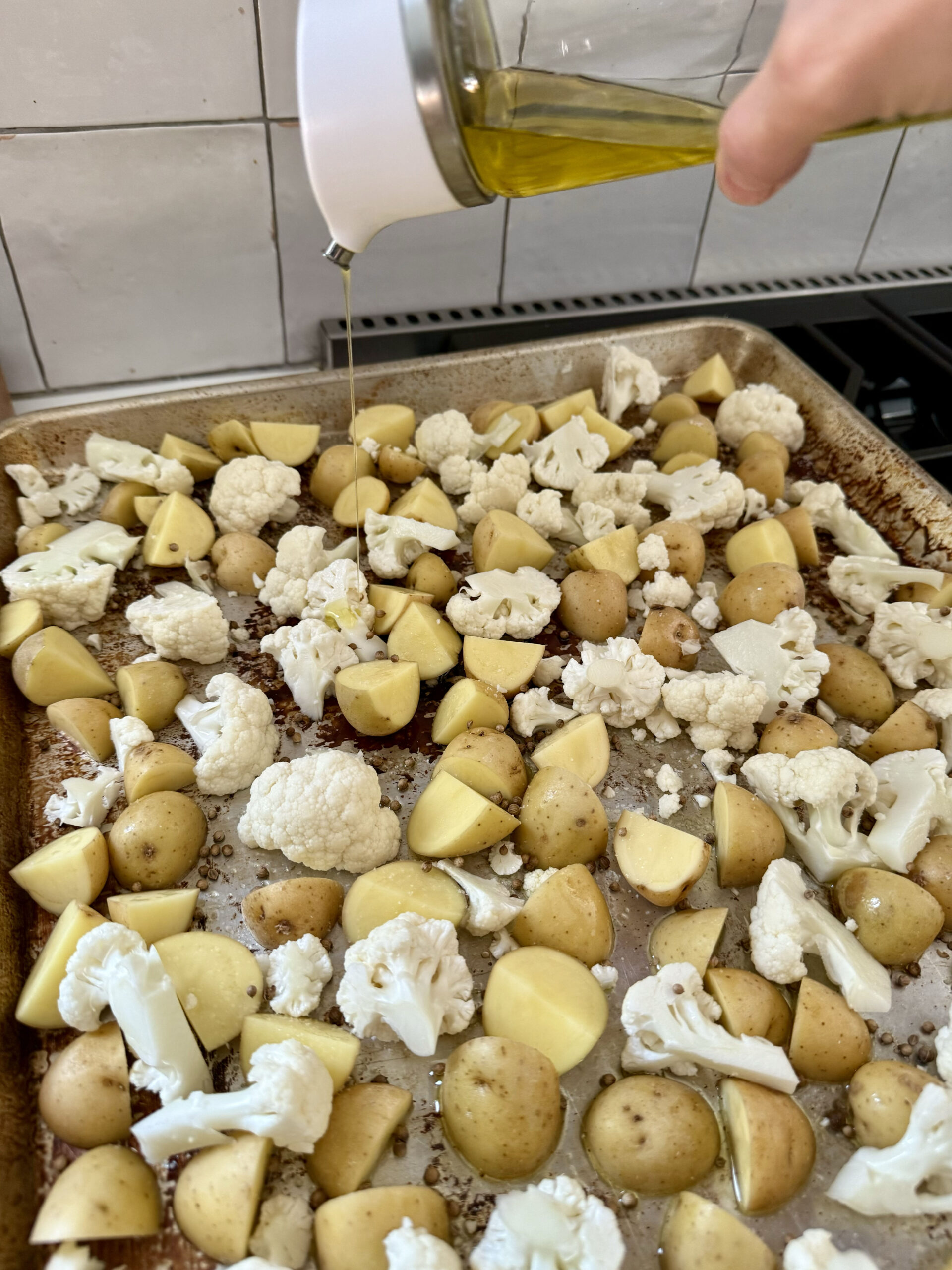 drizzle olive oil on potatoes and cauliflower