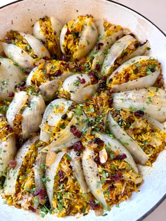 Jeweled rice-stuffed onions garnished with pomegranate seeds and herbs for Thanksgiving