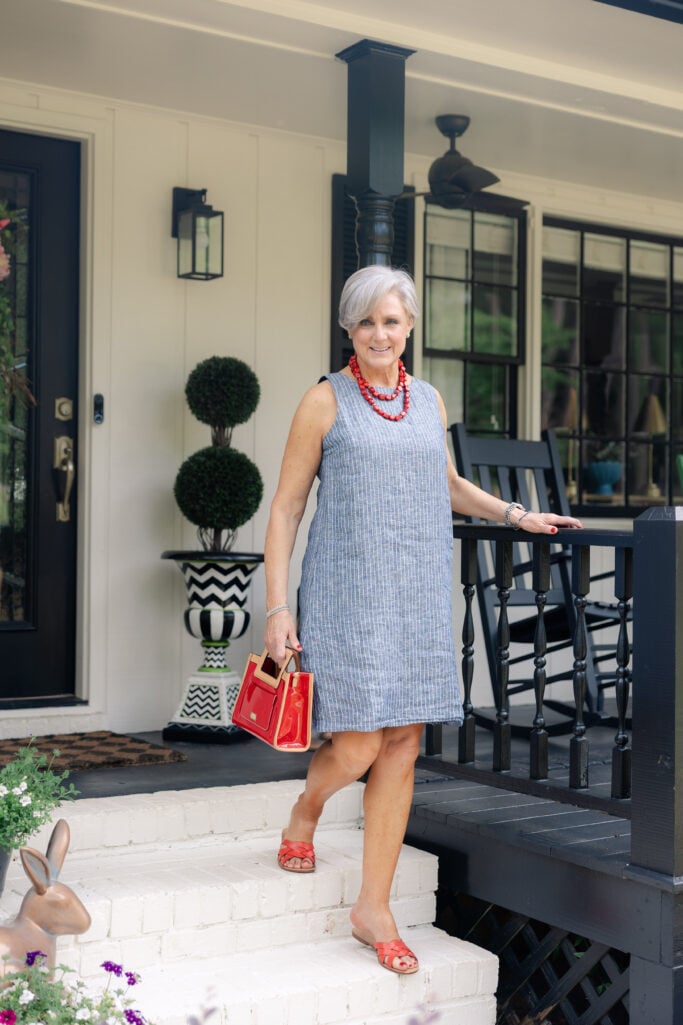 Beth Djalali wearing a sleeveless shift dress with red accessories – stylish summer look for mature women