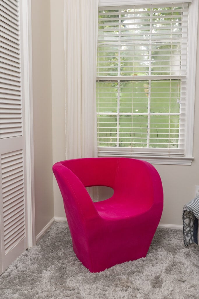 Feminine bedroom with pink art and striped bedding—reclaiming space after grief