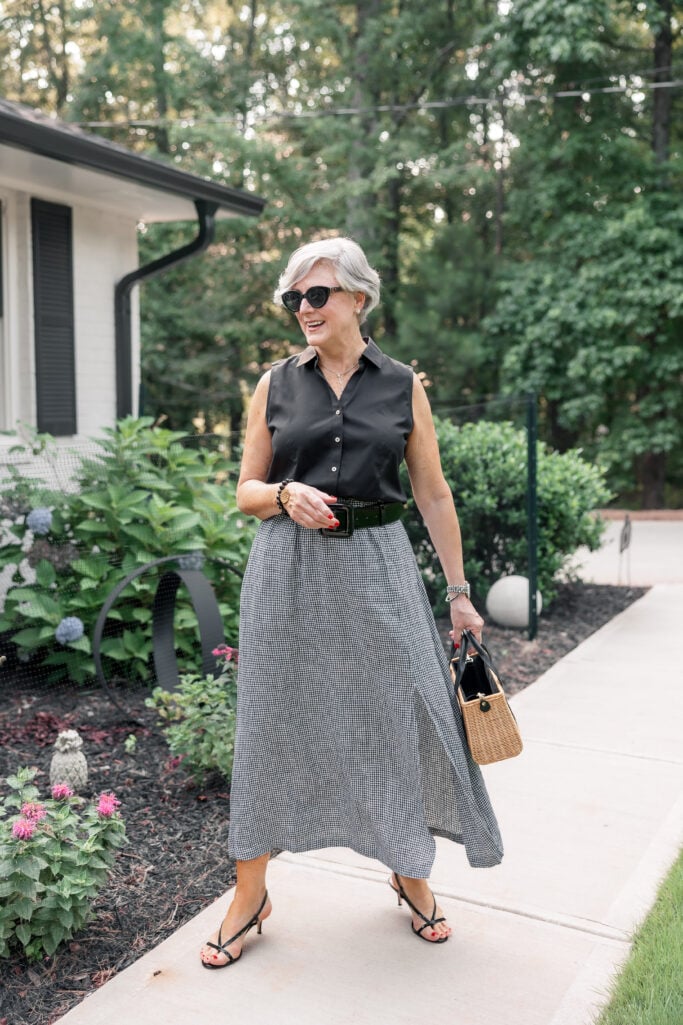 A black-and-white linen skirt and sleeveless top styled as a polished summer outfit for women over 50