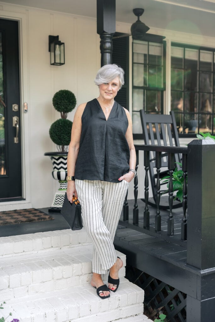 A neutral linen top and pants set styled with sunglasses and leather sandals—a breathable summer outfit formula for women over 50