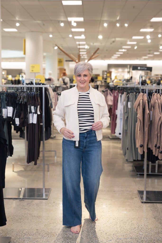 Woman over 50 wearing boucle bomber jacket and wide-leg jeans at Nordstrom
