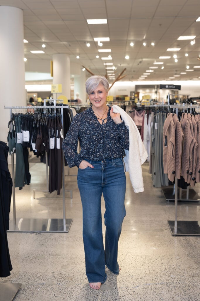 Woman in flared Kut from the Kloth jeans and a printed blouse at Nordstrom