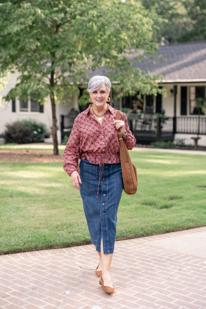 Beth Djalali wearing a printed fall blouse and denim skirt, a transitional summer-to-fall outfit