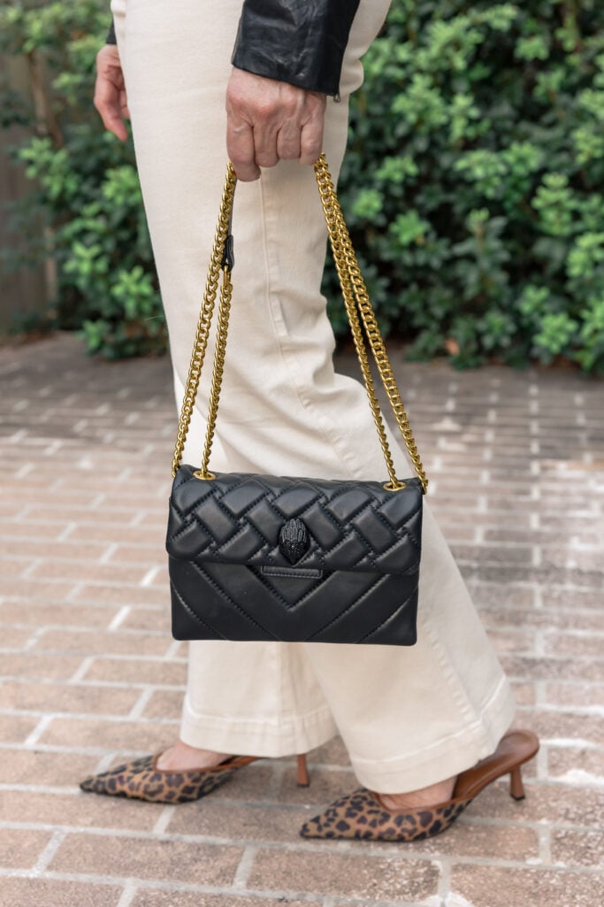 Stylish woman in black leather jacket, cream jeans, and leopard heels.