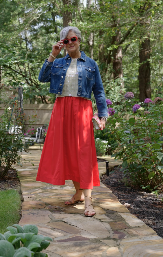 Beth Djalali in red skirt and denim jacket, styled as an affordable chic fall outfit.