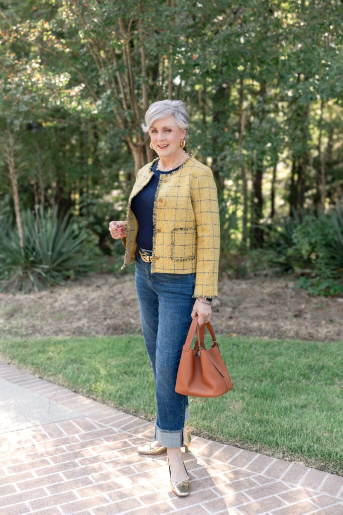 Beth Djalali wearing a yellow plaid jacket with dark denim and gold flats, carrying a brown leather tote for fall style inspiration.