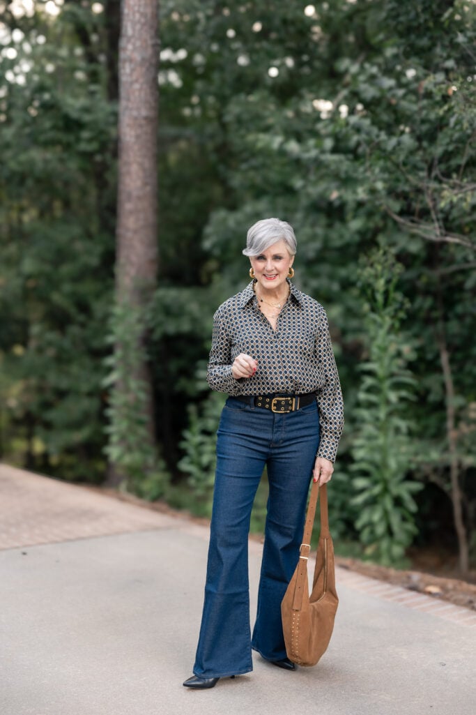 Beth Djalali wearing printed blouse tucked into flared jeans with a wide belt