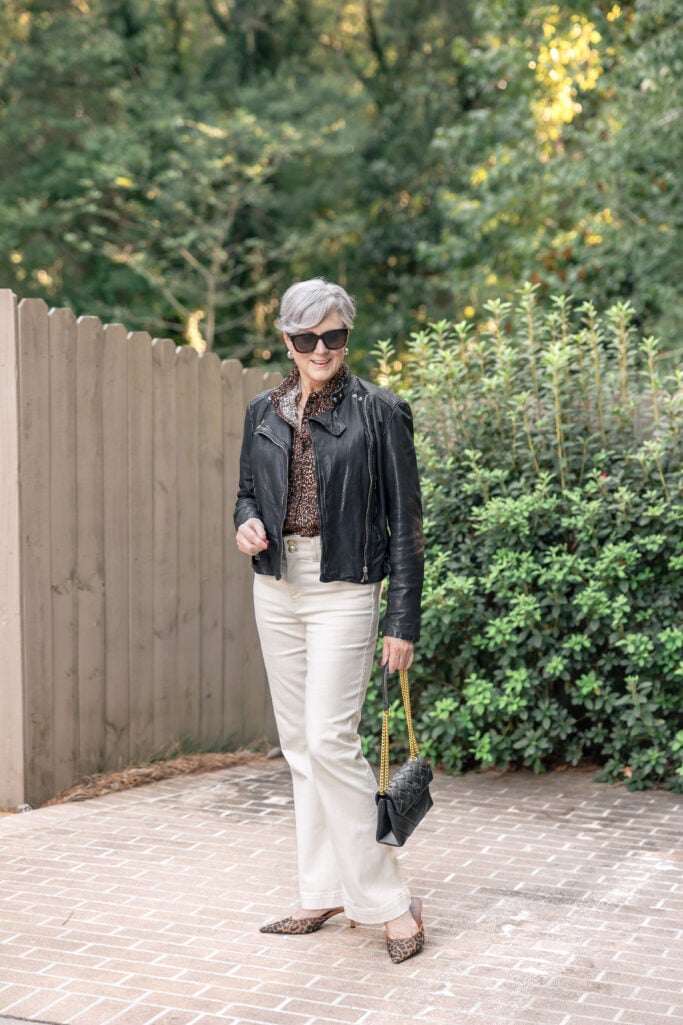 How not to look frumpy and older. Beth Djalali wearing a black leather moto jacket and flare jeans.