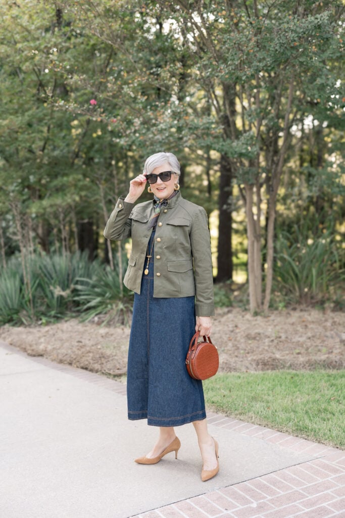  Beth Djalali in olive utility jacket, denim dress, and printed scarf—casual chic fall layering outfit.