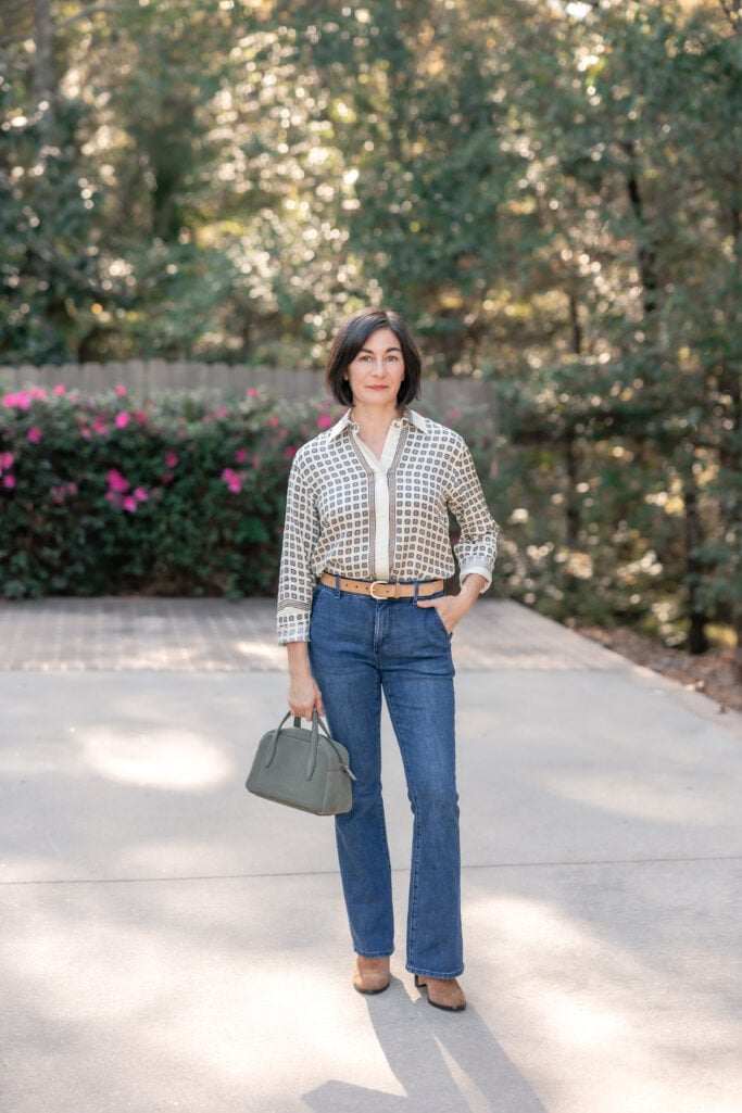 Kelly wearing The Petite Boot Jean from Ann Taylor paired with a printed blouse, suede belt, and brown ankle boots — classic fall outfit for petites.