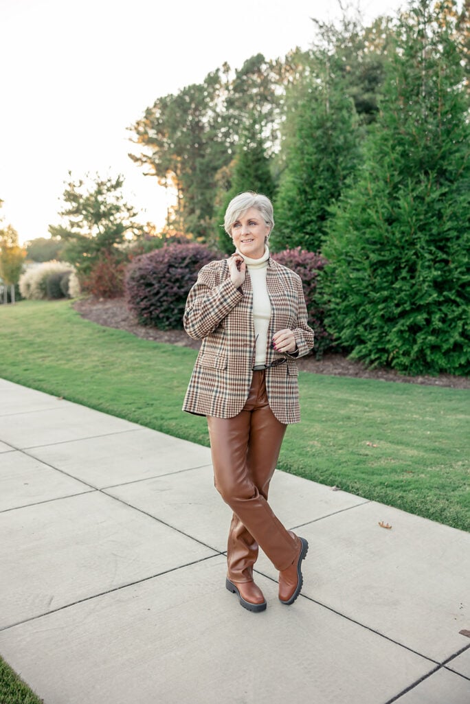Beth wearing a plaid blazer with brown leather pants and Chelsea boots — classic fall outfit idea for women over 50.