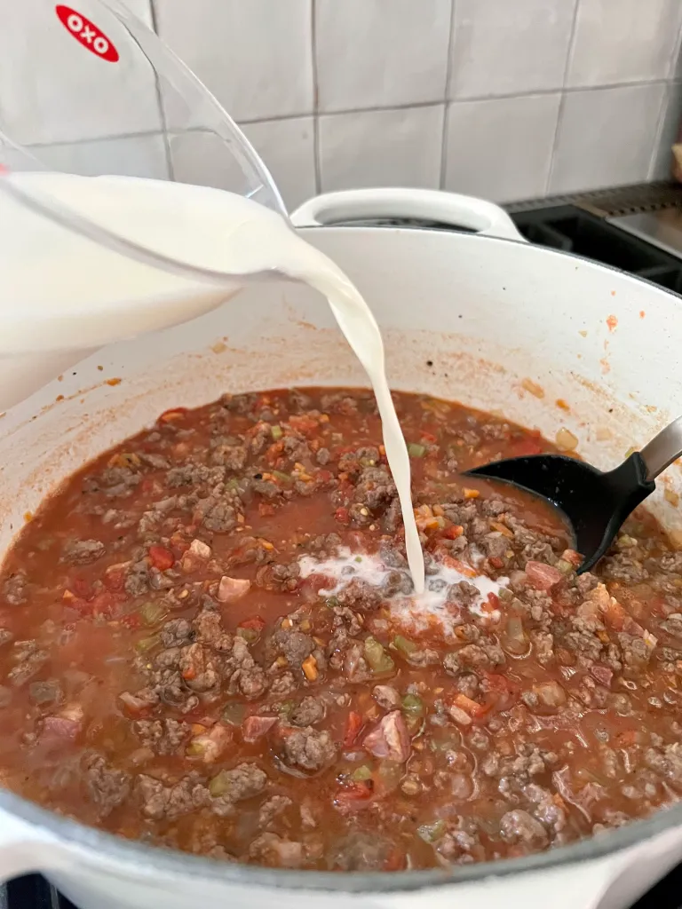 adding milk to the bolognese