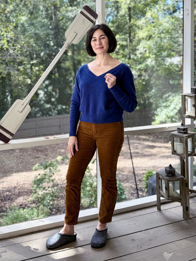Woman wearing a navy sweater and brown corduroy pants