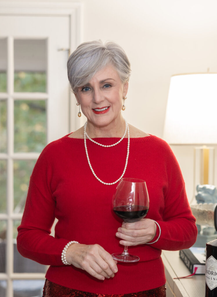 Woman wearing a holiday red sweater and pearls