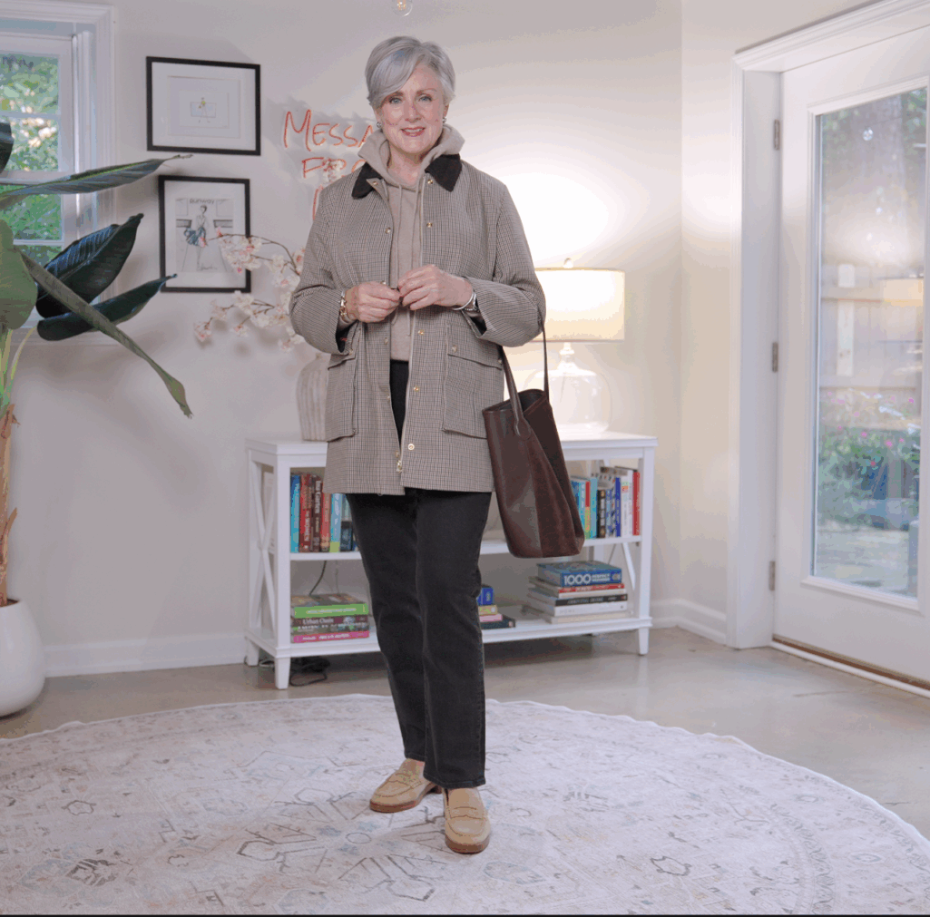 : Beth Djalali wearing a plaid barn jacket with a cream hoodie and dark denim — classic fall outfit for women over 50.