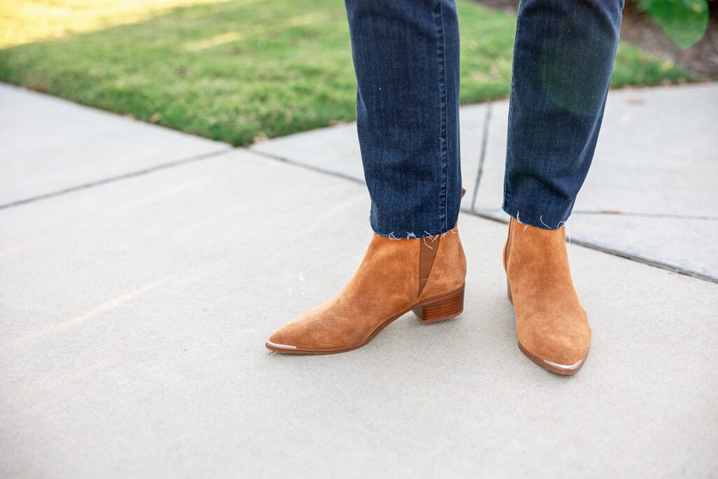 Close-up of tan suede Western-style Chelsea boots paired with dark denim — casual and classic boot look for women 50 and beyond.