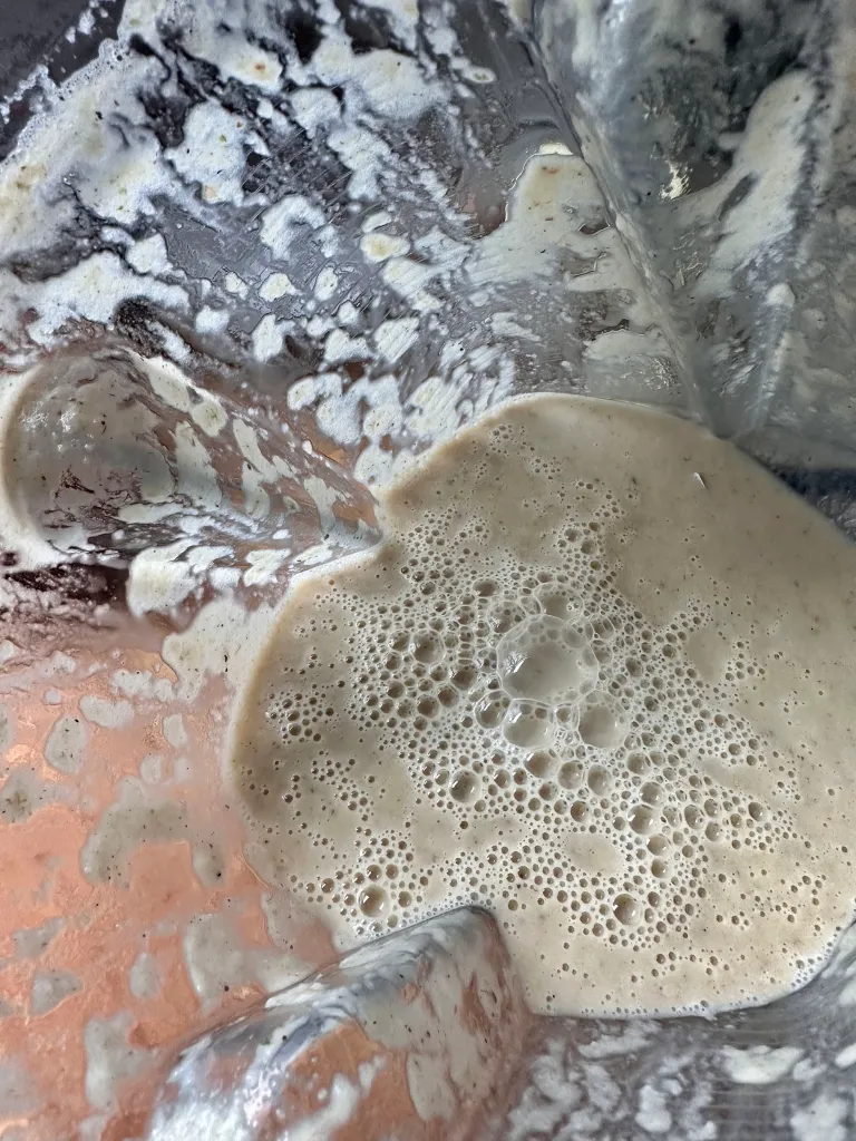 Smooth and creamy pureed cauliflower mixture in blender creating dairy-free base for seafood chowder