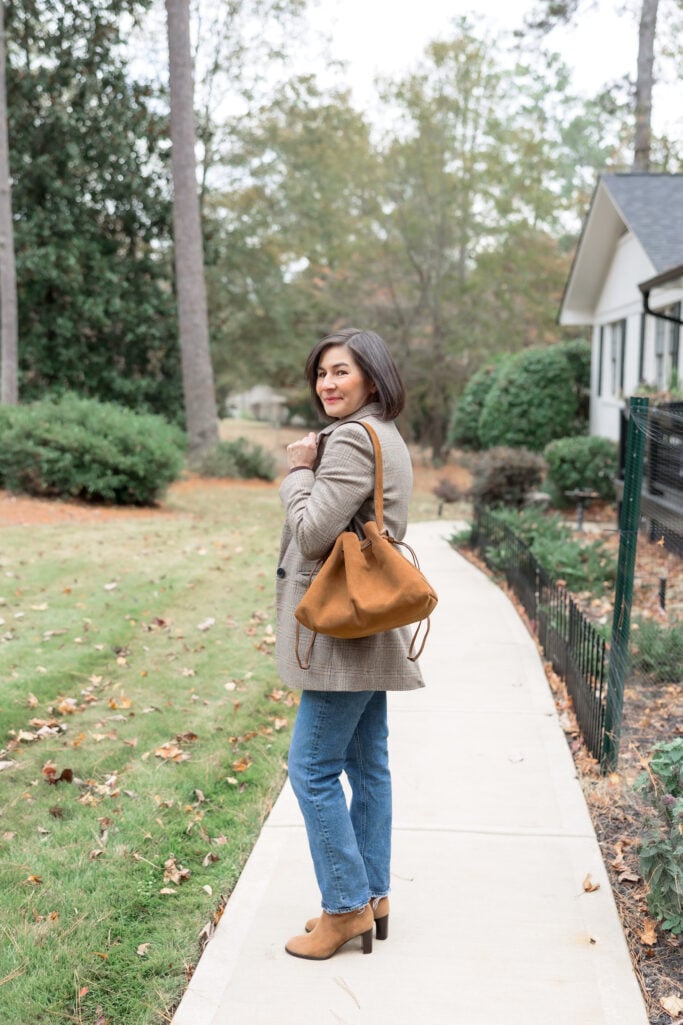 Kelly wearing tan suede drawstring shoulder bag with plaid blazer and espresso sweater - petite everyday outfit